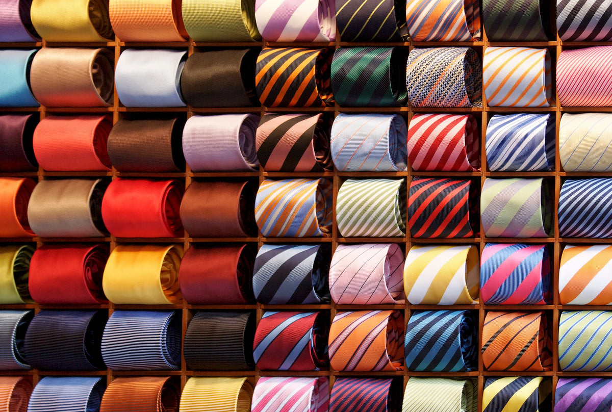 Colorful display of luxury silk ties arranged in rows, showcasing a variety of patterns and colors